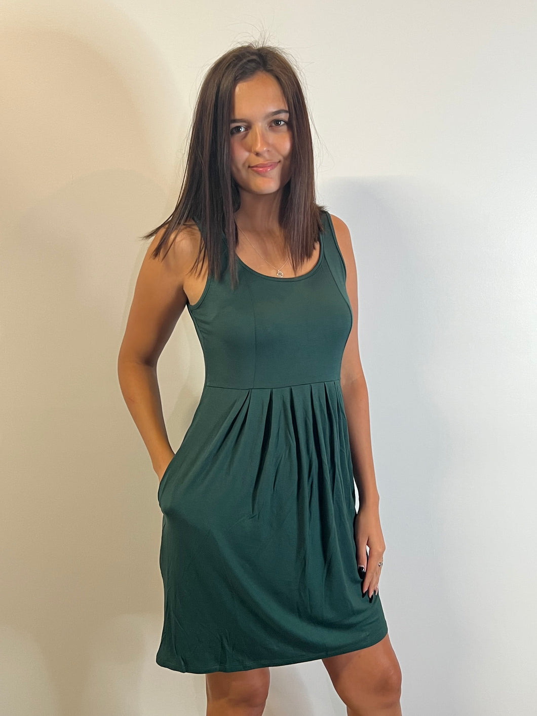 Green sleeveless dress with front pleats and pockets